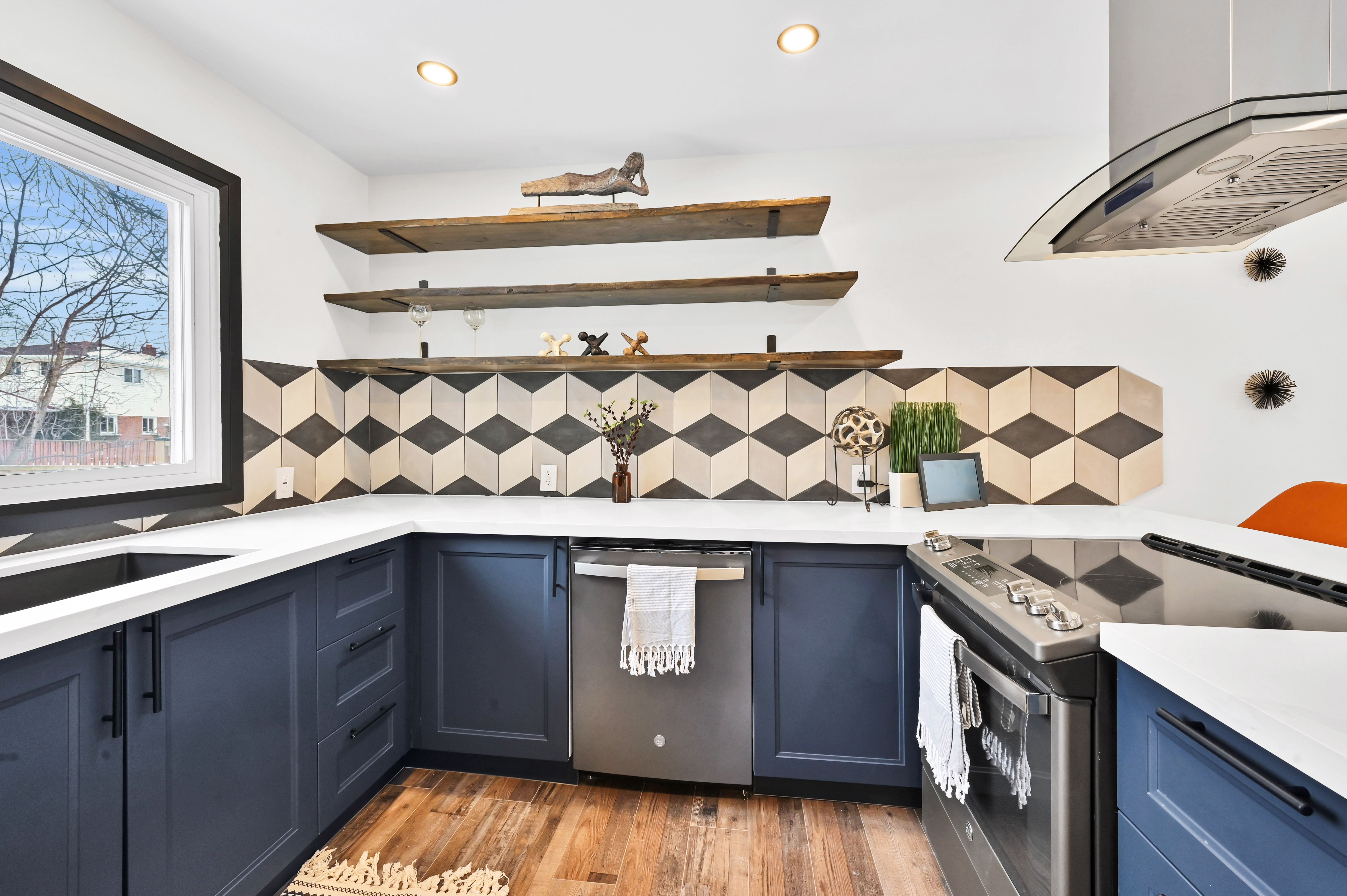 Stunning finished kitchen with dramatic geometric backsplash, navy cabinets, and excellent natural light — premium portfolio shot — Kron, Hamilton | MTC Renovations